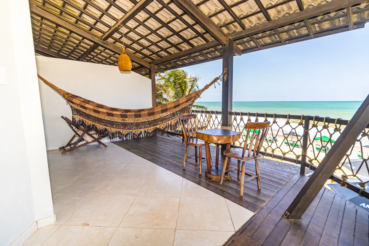 Varanda com rede, mesa e vista para o mar